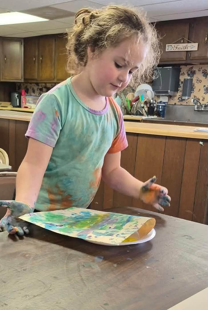 A student painting at the kitchen counter