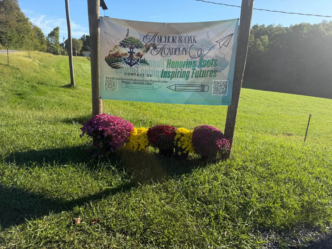 The Anchor & Oak Academy sign with fall flowers